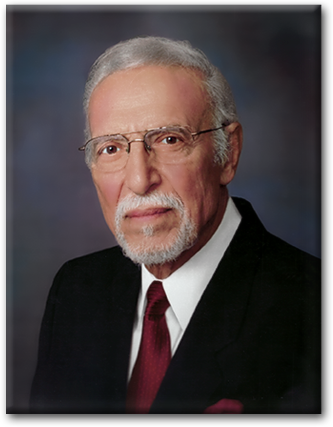A man with glasses and a beard wearing a suit