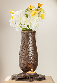 A vase with flowers in it is sitting on the floor.